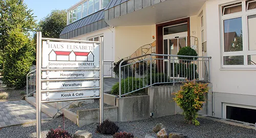 Eingangsbereich des Seniorenheims mit großem Wegweiserschild